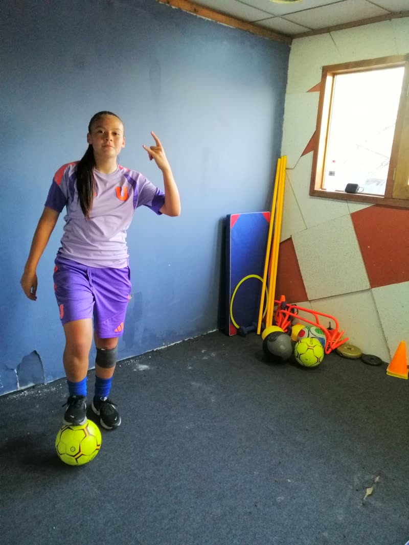 Alumna con el balón bajo el pie en la sala de entrenamiento