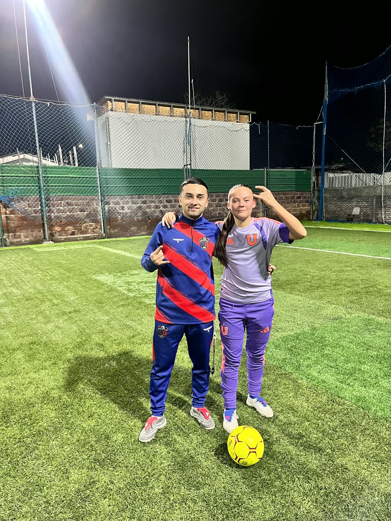 Matías Ortega junto a una alumna en la cancha, con el balón a sus pies